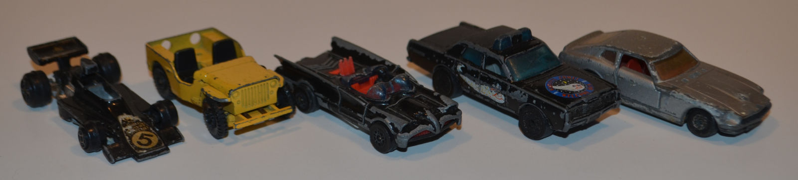 Open wheel car is a John Player special w/ only the front sticker remaining. The black sedan is a Haleys Comet car