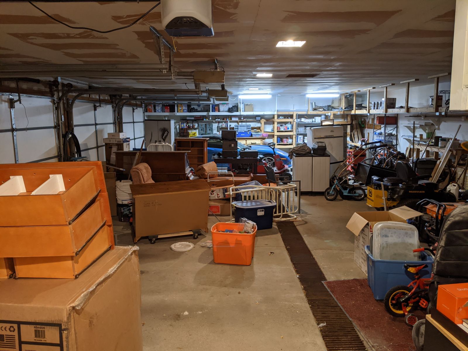 Garage full of crap, blue car in the distance
