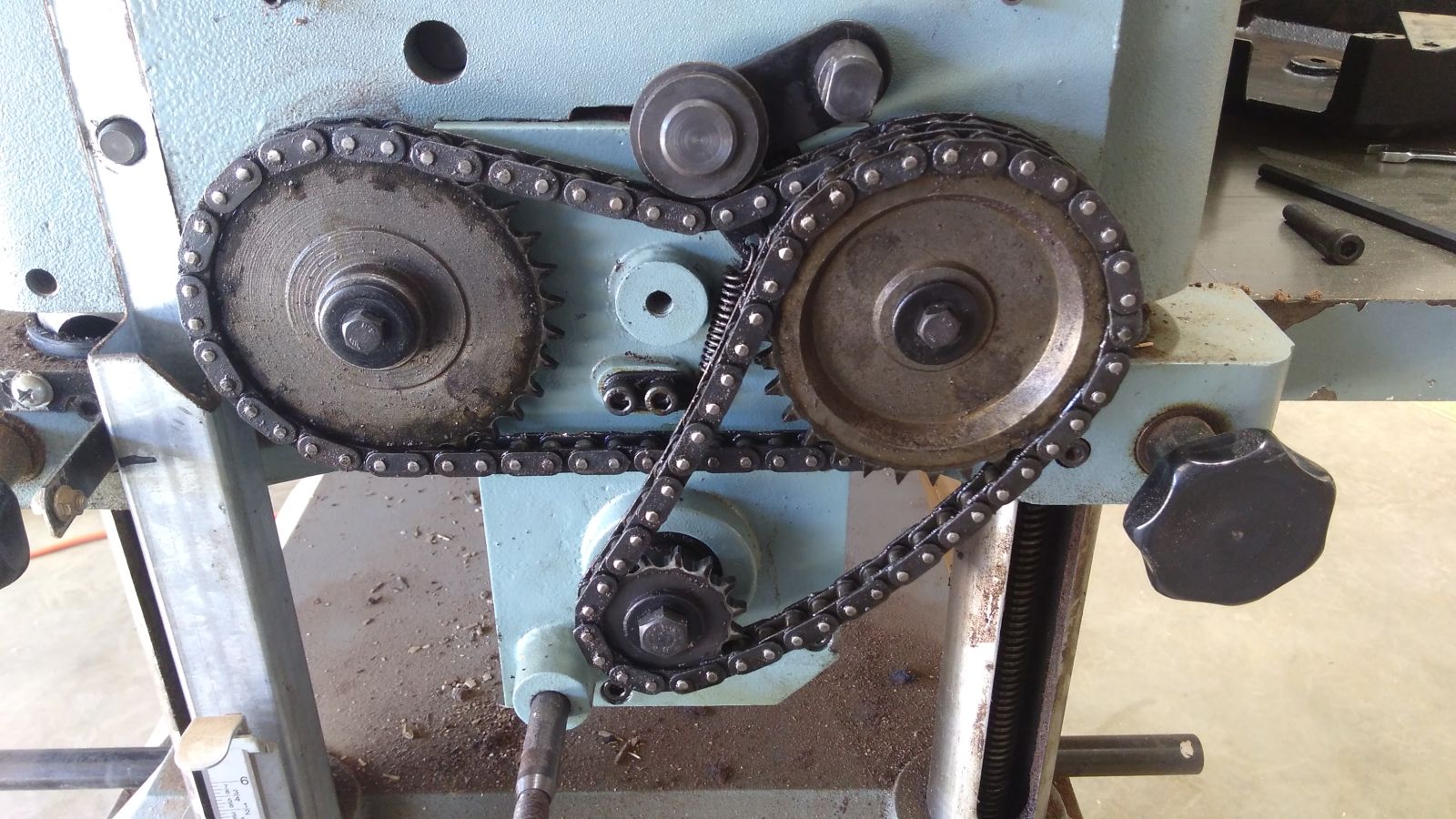 The gearbox is behind those sprockets. It directs the drive off the motor via the cutter bar to both the in and out feed rollers behind the bigger sprockets. The rod at the bottom left corner is the gearstick.