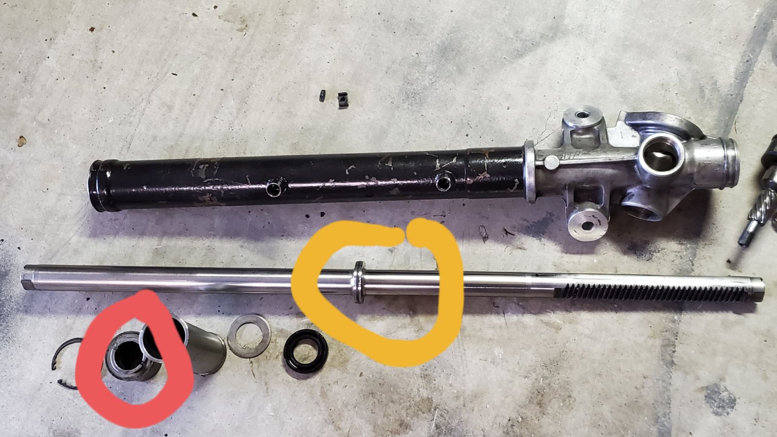 Without bushing (red circle) the only force holding the rack center is pressure between the steering shaft and pressure spring pushing on the back of the rack.