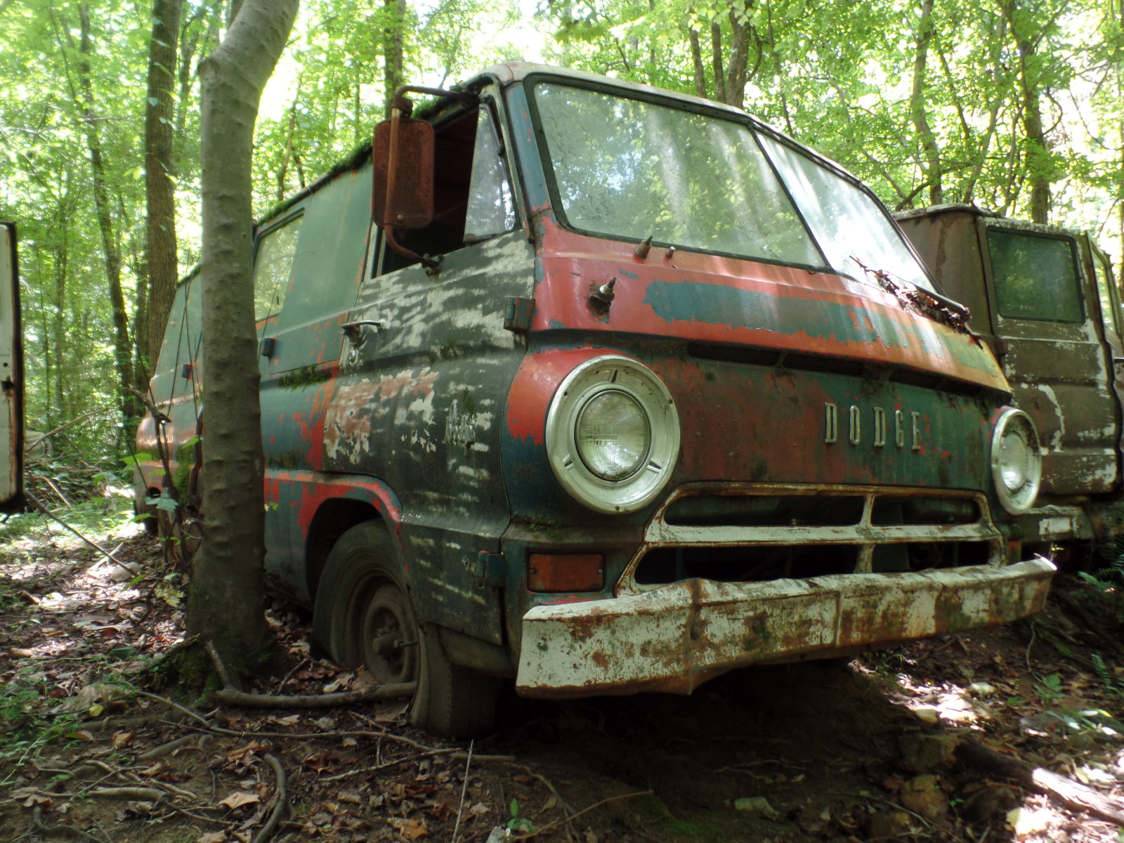 A Dodge A100, one off the last Detroit cab-over-engine vans. This example sat in a line of other commercial vans from the same era, all showing multiple paint colors from their various liveries.