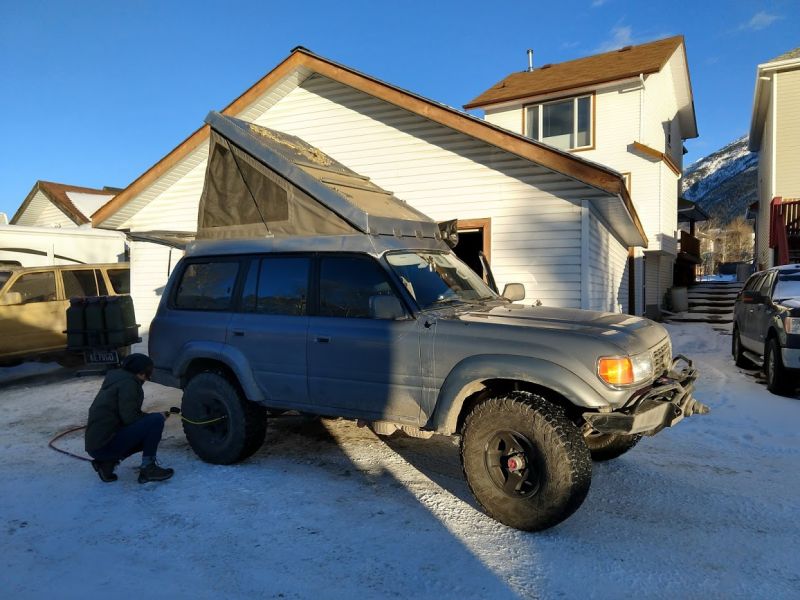 You can see his topless 80 in the background. He’s got a donor truck that he’ll move all of the nice offroad parts over too. The tan truck is rusty and dented up good. You can see we never finished stripping the paint off the roof.