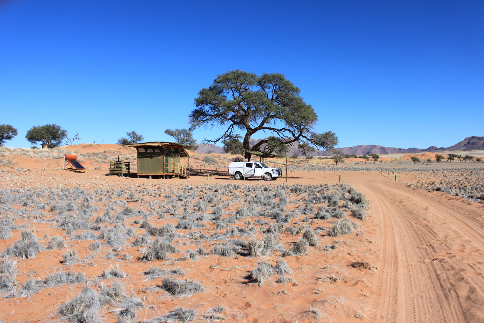 Orion Campsite, NamibRand Nature Reserve, Namibia. If you squint, you can see me airing up the tires for the drive back to Windhoek, and, eventually, home.