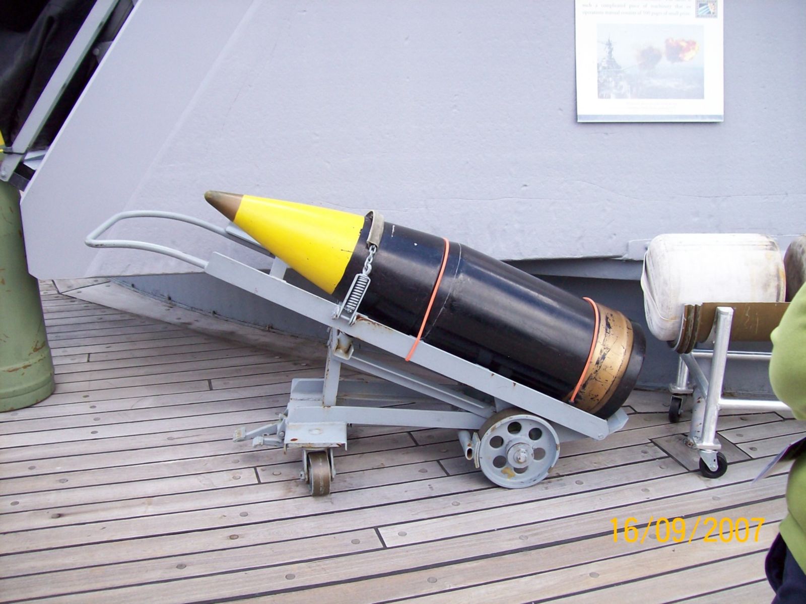 One of the Mark 7 shells on a trolley, along with a propellant bag. Up to six bags would launch the shell a maximum of 42,000 yards