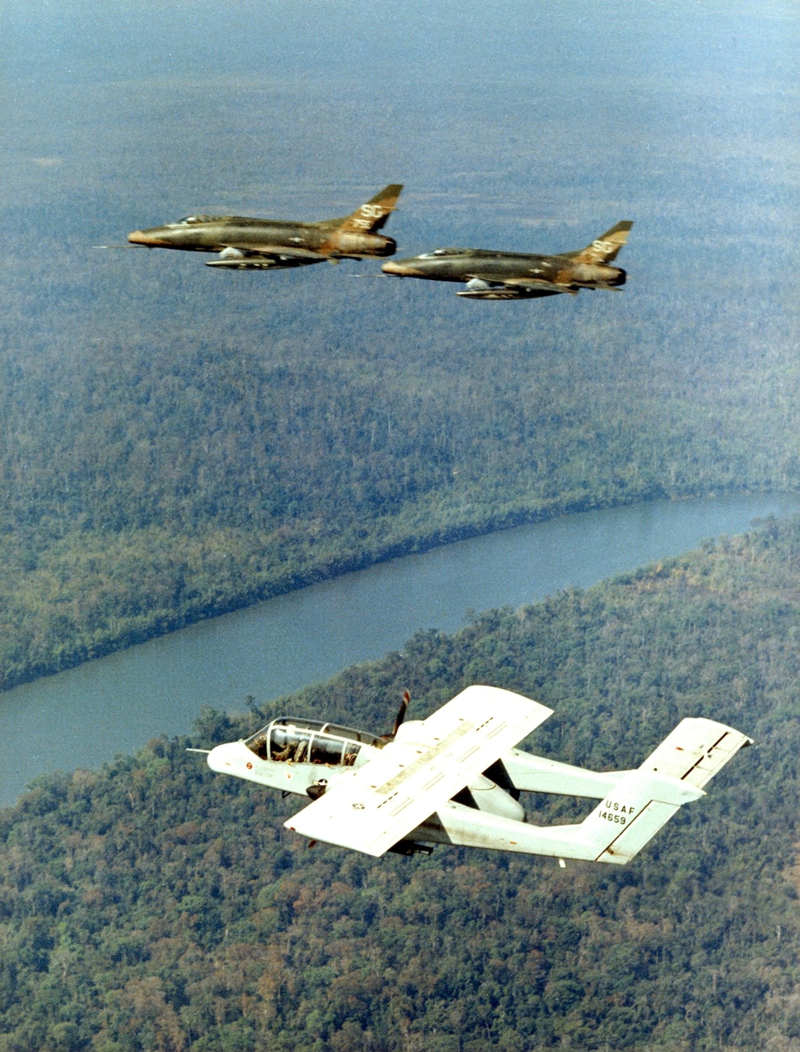 OV-10A acting as FAC for two F-100C Super Sabre fighter/bombers over Vietnam, circa 1969