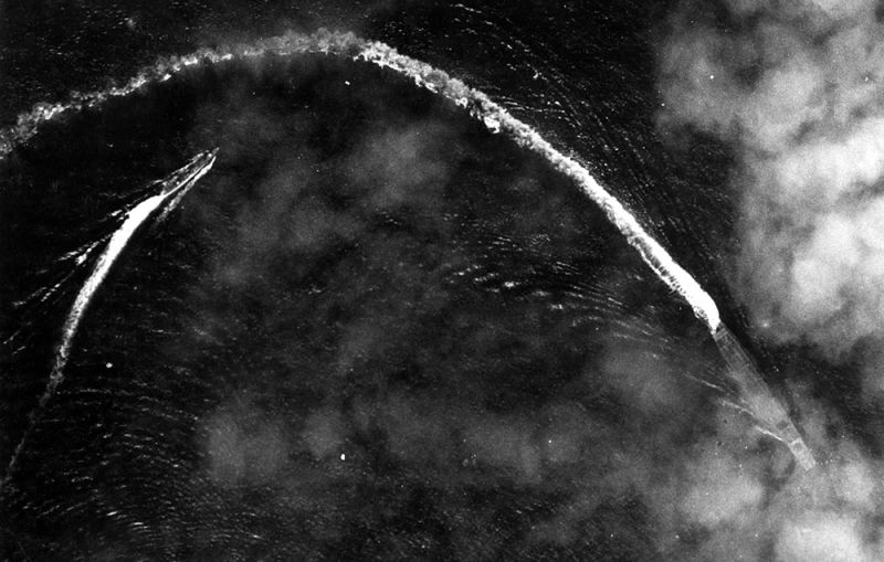 The Japanese carrier Akagi, trailed by a cruiser, turns to dodge the bombs dropped by American B-17s. (US Air Force)