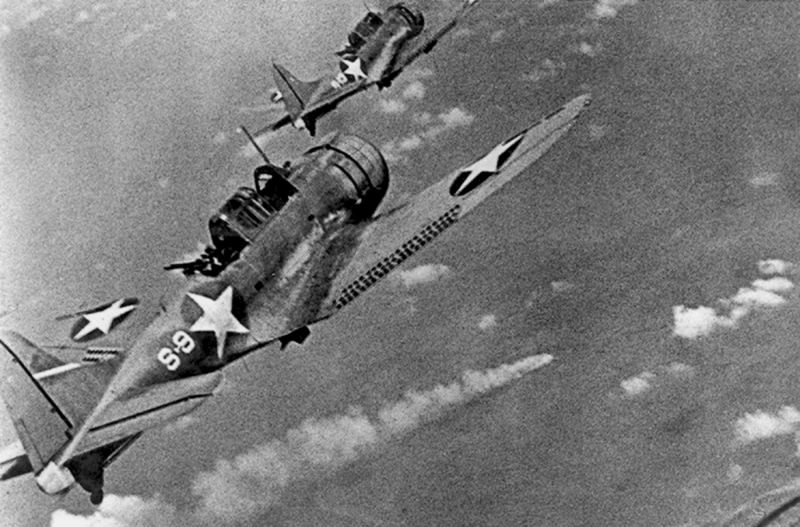 US Navy Douglas SBD Dauntless dive bombers from USS Hornet fly over the burning Japanese cruiser Mikuma during the Battle of Midway (US Navy)