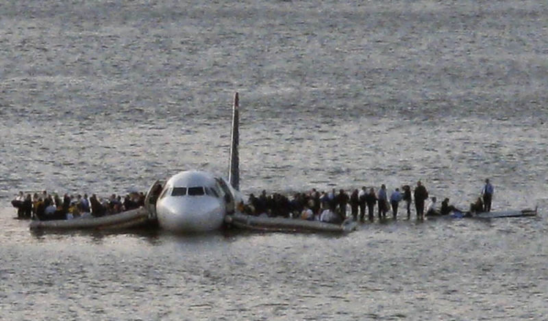 Flight 1549 floats slowly down the Hudson River as passengers gather on the wings and in life rafts. (Steven Day/AP)