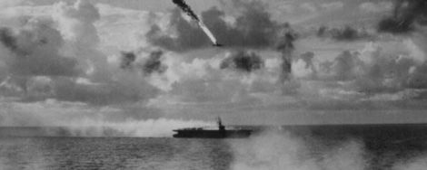 A Japanese dive bomber goes down in flames while attacking the escort carrier USS Kitkun Bay (CVE-71). (US Navy)