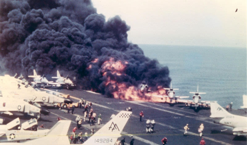 Flames erupt on the Forrestal’s flight deck moments after a malfunctioning rocket launched across the deck and struck an A-4 Skyhawk awaiting takeoff (US Navy)
