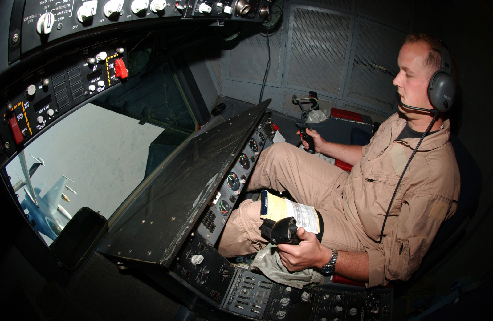 The refueling boom operator, or “Boomer,” sits at his station while refueling a US Air Force F-16C over Iraq in 2004. On the Extender, the Boomer sits comfortably, while the boom operator on the smaller KC-135 must lie face down.