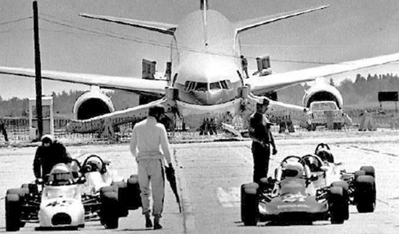 The Gimli Glider, with escape chutes still attached, rests on its collapsed nosewheel behind the racetrack at the closed airstrip.