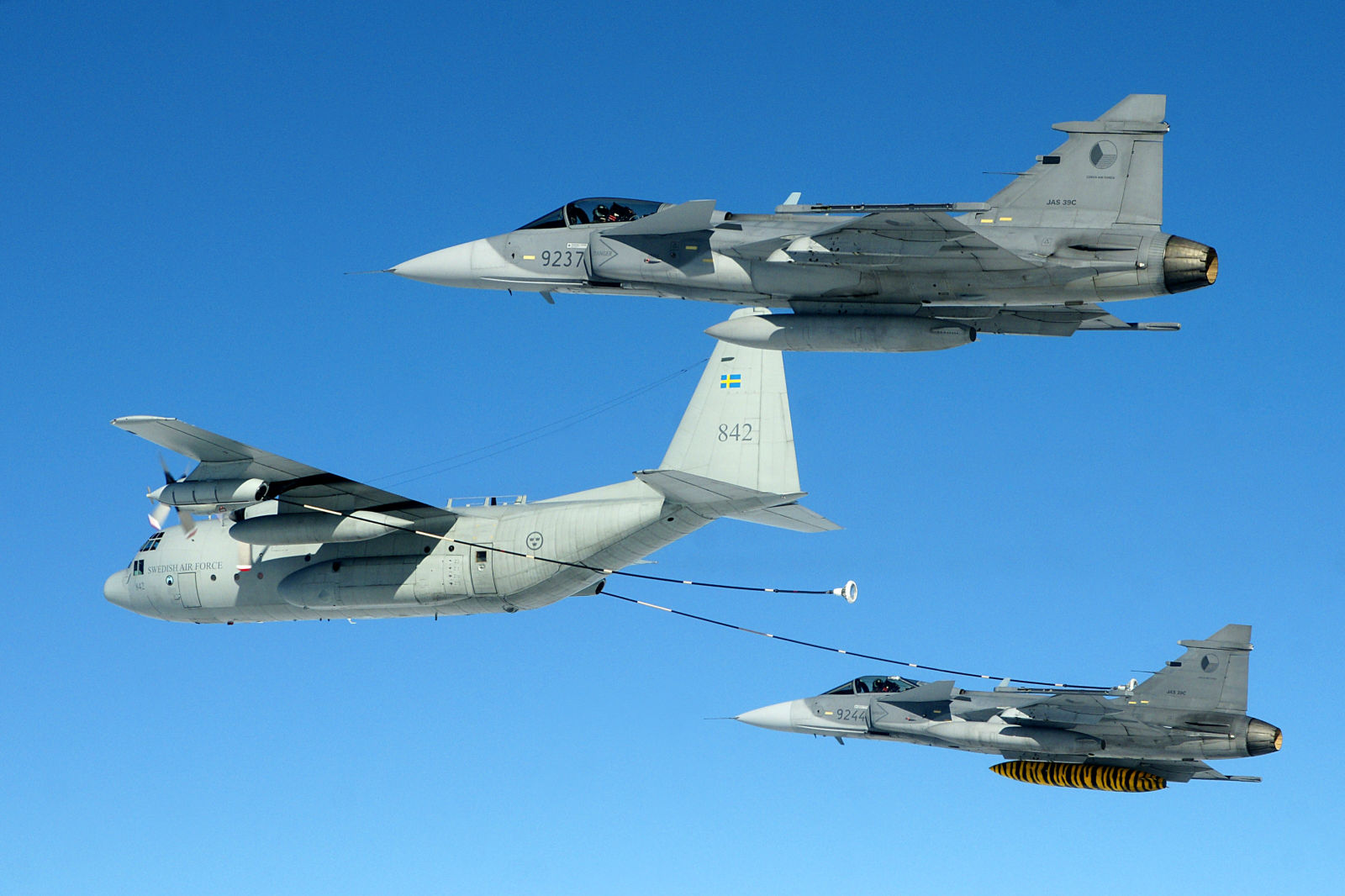 Two Saab JAS-39 fighters of the Czech Air Force receive fuel from a Swedish Air Force Hercules in 2016